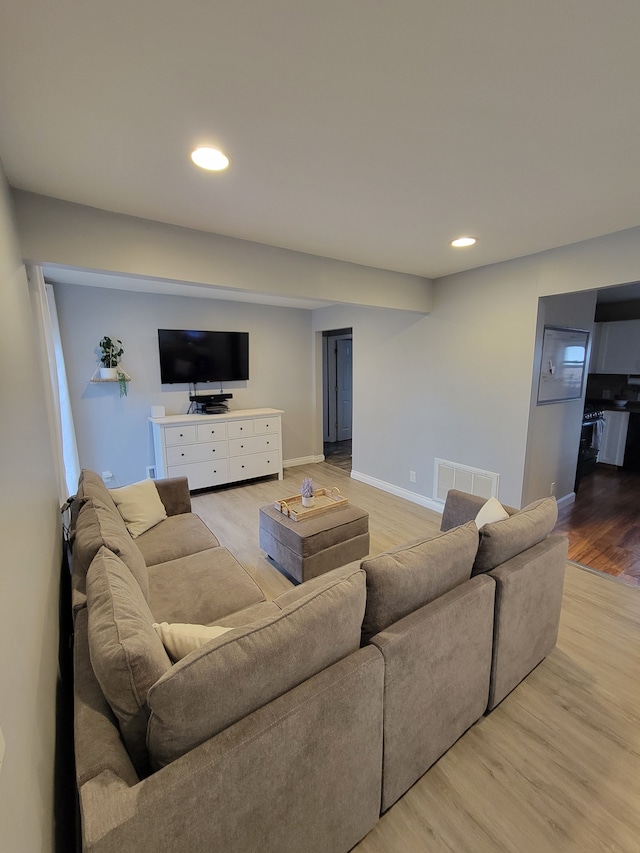 living area with light wood finished floors, baseboards, visible vents, and recessed lighting