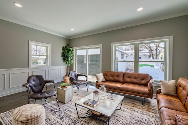 living room featuring wainscoting, ornamental molding, wood finished floors, and plenty of natural light