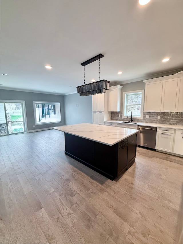 kitchen with backsplash, dishwasher, a sink, a kitchen island, and open floor plan