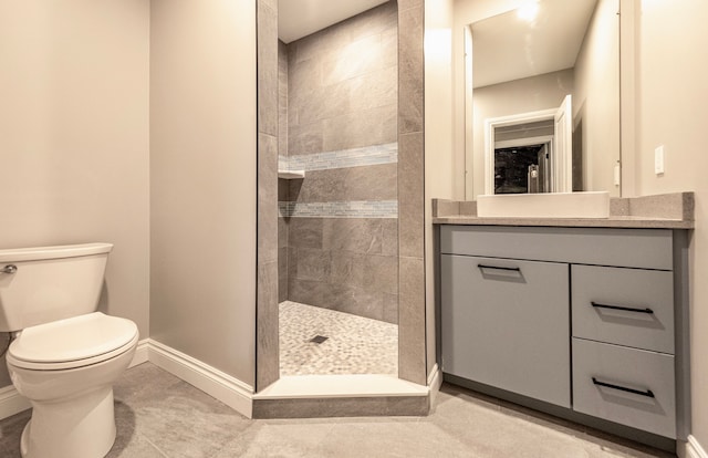 bathroom with walk in shower, baseboards, vanity, and toilet