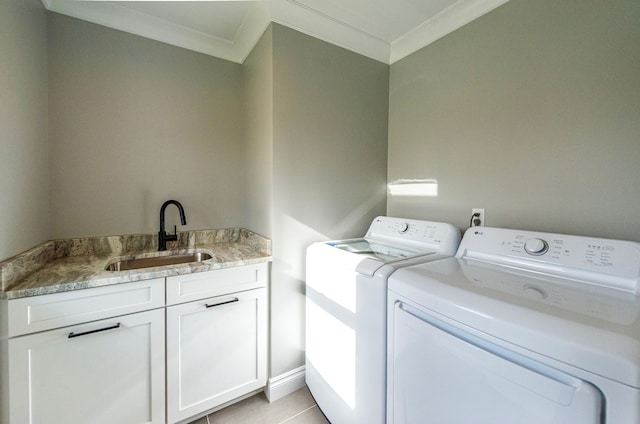 laundry room with a sink, light tile patterned floors, cabinet space, ornamental molding, and independent washer and dryer