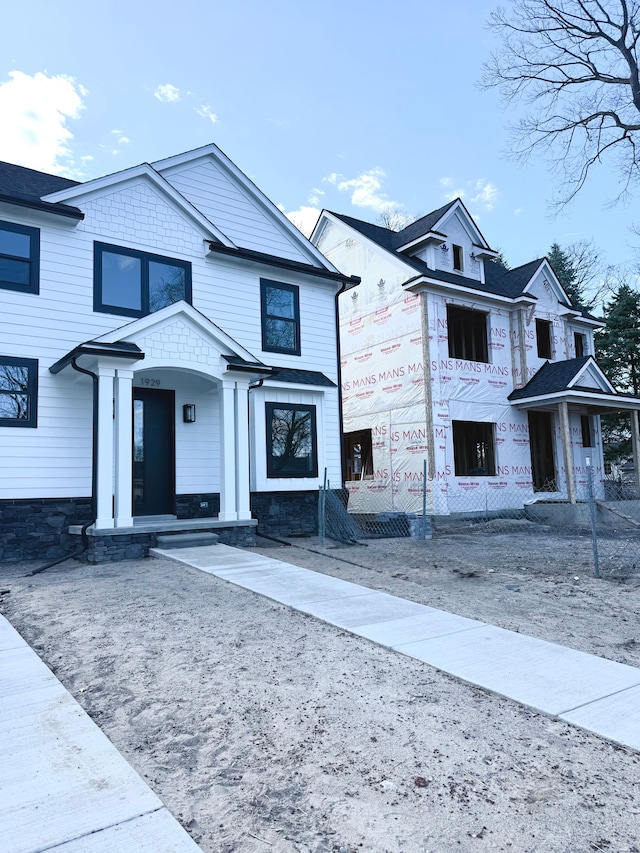 view of front of house featuring stone siding and a fenced front yard