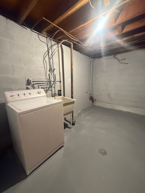 unfinished basement with washer / clothes dryer and a sink