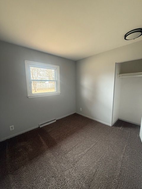 unfurnished bedroom with dark carpet