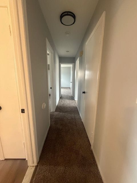 hallway with carpet and baseboards