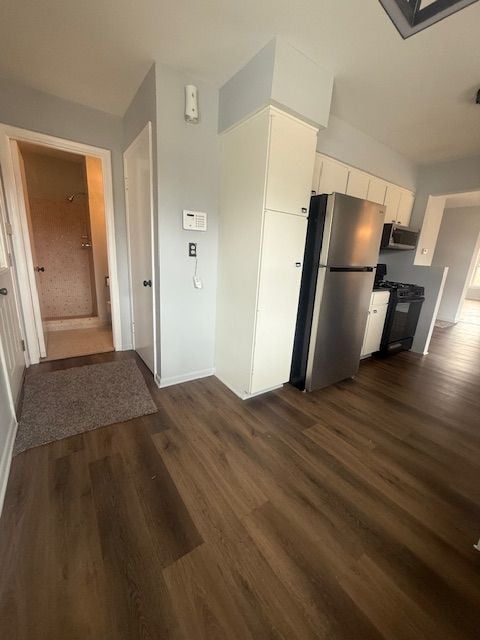 kitchen with baseboards, stainless steel appliances, dark wood-style flooring, and white cabinets