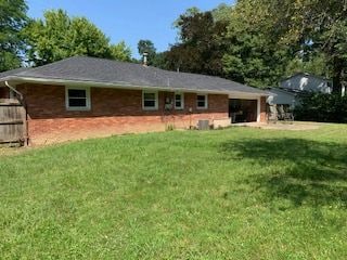 back of property with a garage and a lawn