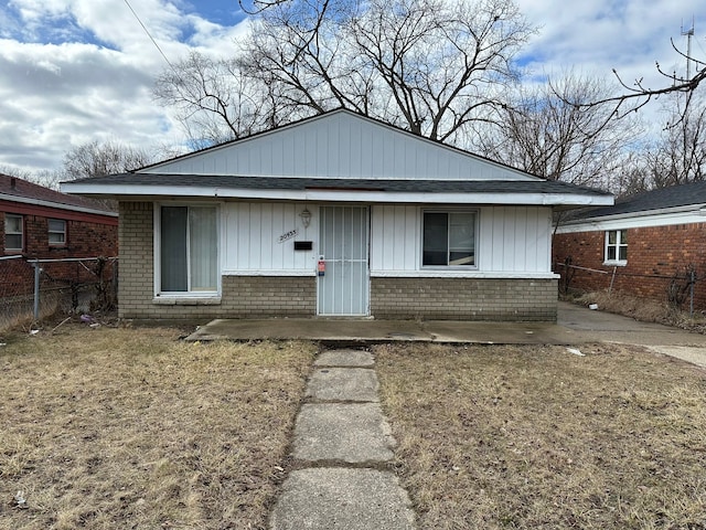 view of front of property featuring brick siding and fence