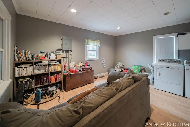 living room featuring crown molding, light wood-style floors, and washer and dryer