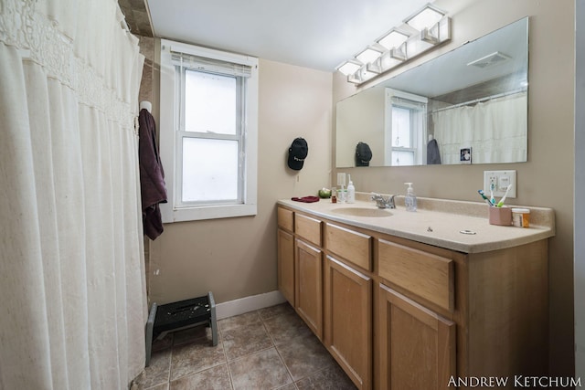 full bath featuring visible vents, vanity, baseboards, and tile patterned floors