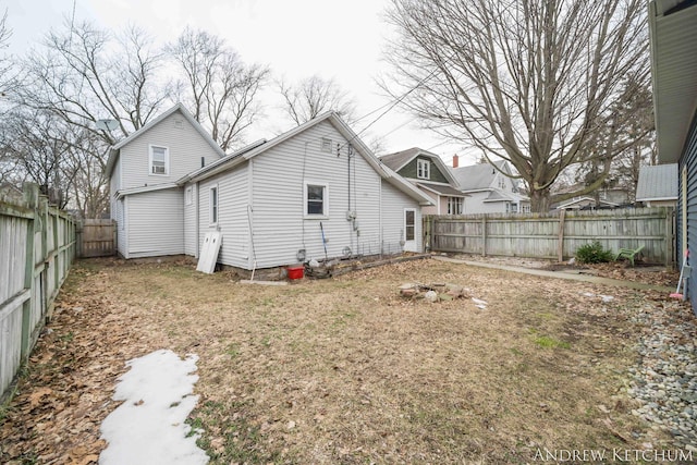 rear view of house featuring a fenced backyard