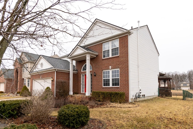 view of front of house with brick siding, fence, and an attached garage