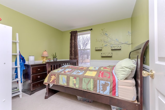 carpeted bedroom featuring a wainscoted wall