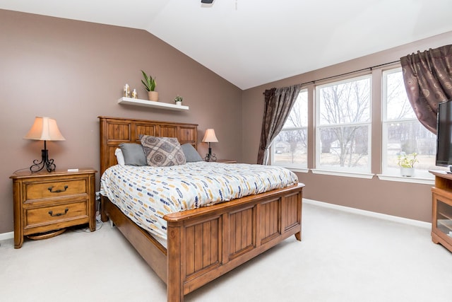 bedroom with light carpet, vaulted ceiling, baseboards, and multiple windows