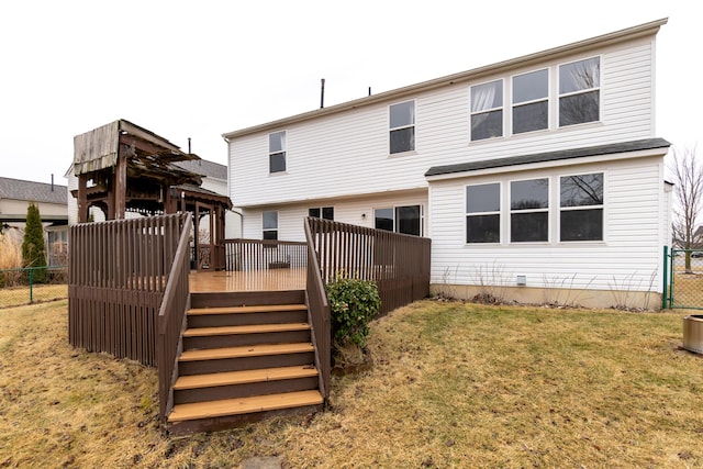 rear view of property featuring a deck, a yard, stairway, and fence