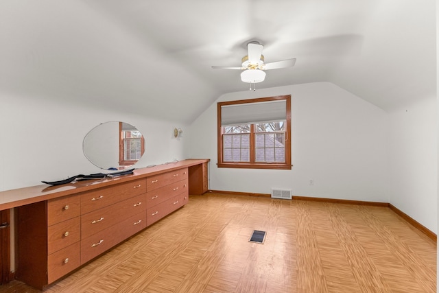 additional living space with lofted ceiling, ceiling fan, visible vents, and baseboards