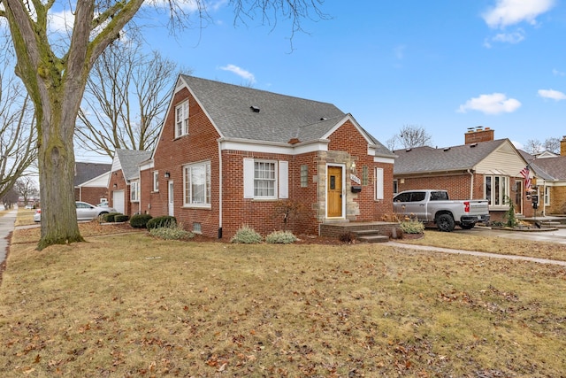 view of front facade with a shingled roof, brick siding, and a front lawn