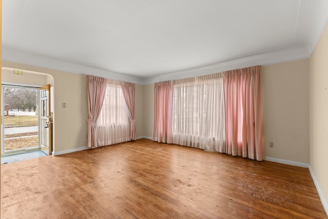 empty room with baseboards and wood finished floors