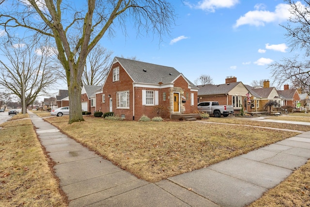 view of front of property featuring crawl space, brick siding, a front lawn, and a residential view