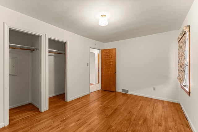 unfurnished bedroom featuring a closet, visible vents, light wood-style flooring, and baseboards