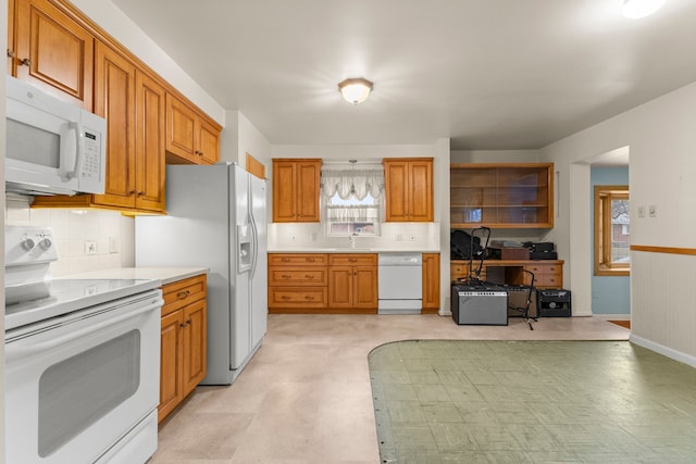 kitchen with white appliances, light countertops, light floors, and brown cabinetry