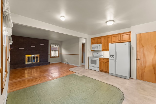 kitchen with white appliances, a fireplace, baseboards, light countertops, and light floors