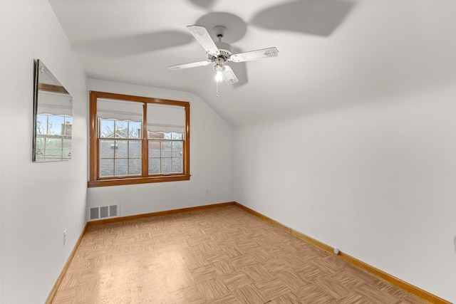 additional living space featuring a ceiling fan, lofted ceiling, visible vents, and baseboards