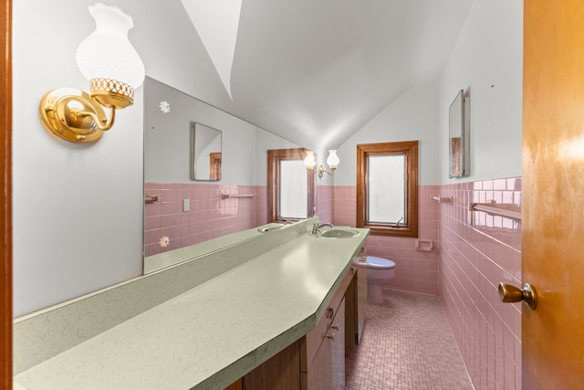 half bath featuring toilet, tile patterned floors, vaulted ceiling, vanity, and tile walls