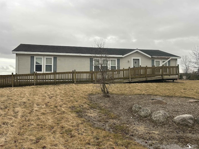 view of front of home featuring fence, a deck, and a front yard