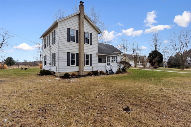 view of front of property featuring a front yard, a chimney, and entry steps