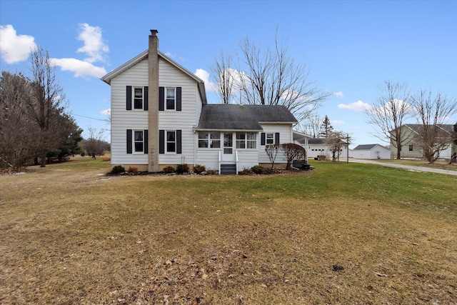 back of house with a lawn and a chimney