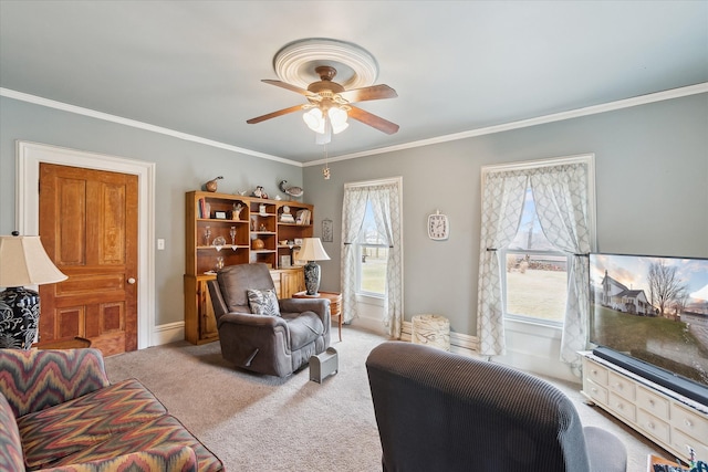 living area featuring ceiling fan, carpet floors, ornamental molding, and baseboards