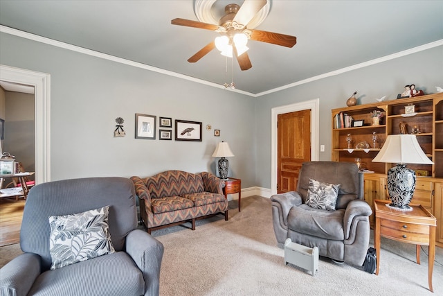 living room with ceiling fan, baseboards, crown molding, and carpet flooring