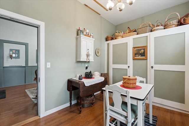 dining room with a notable chandelier, baseboards, and wood finished floors