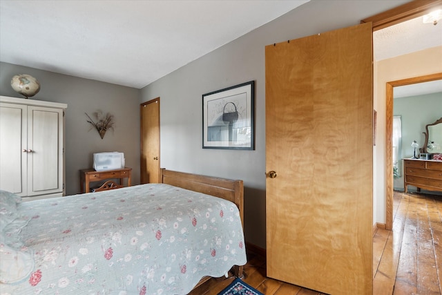 bedroom with baseboards and hardwood / wood-style flooring