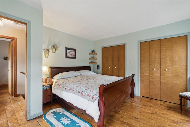 bedroom featuring multiple closets and light wood-style floors