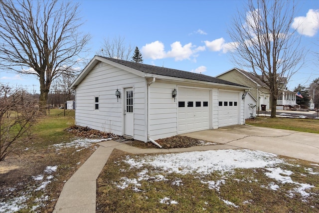 snow covered garage with driveway