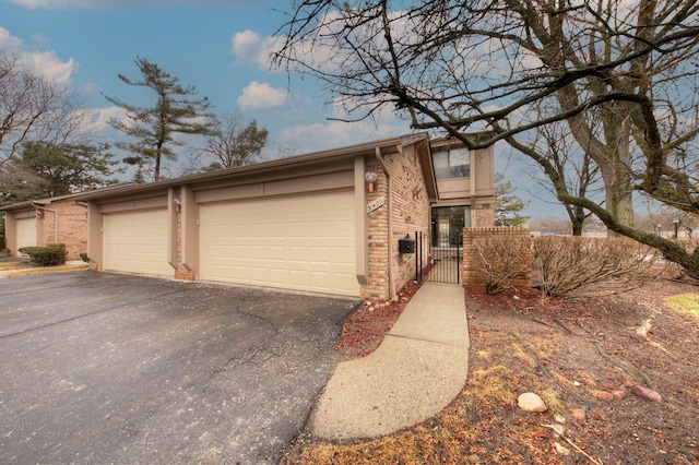 view of front of property with a garage, a gate, and brick siding