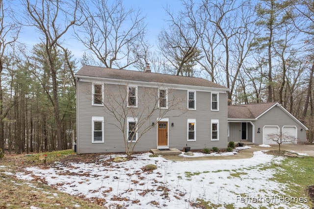 colonial home with a garage and a chimney