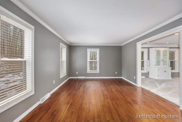 empty room with a healthy amount of sunlight, visible vents, and baseboards