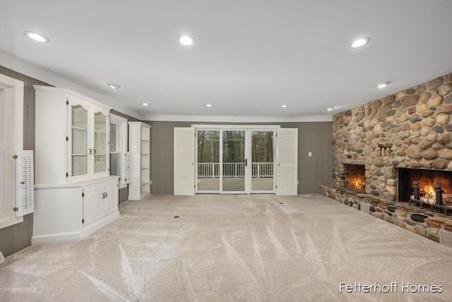 unfurnished living room with light carpet, a fireplace, and recessed lighting