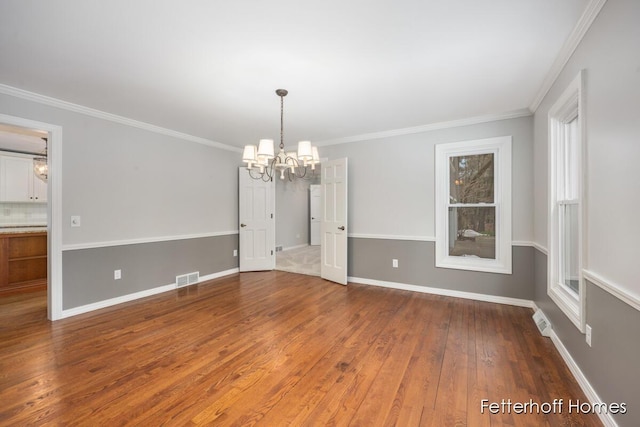 unfurnished dining area featuring baseboards, visible vents, a chandelier, and wood finished floors