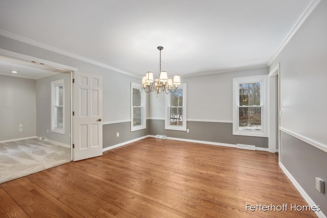 unfurnished dining area with baseboards, wood finished floors, visible vents, and a notable chandelier