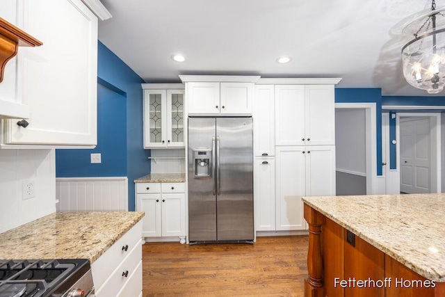 kitchen with dark wood-type flooring, stainless steel fridge, and white cabinetry