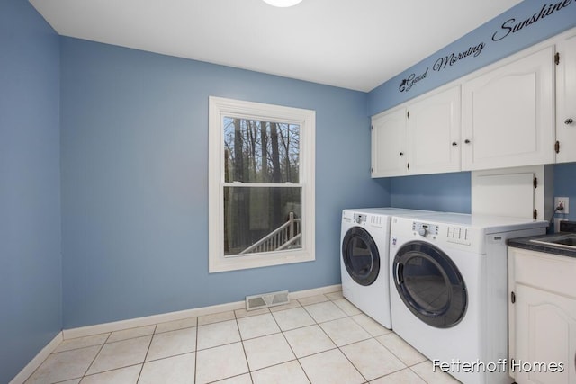 laundry room featuring light tile patterned floors, cabinet space, visible vents, separate washer and dryer, and baseboards