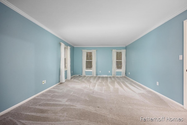 carpeted empty room featuring baseboards and crown molding