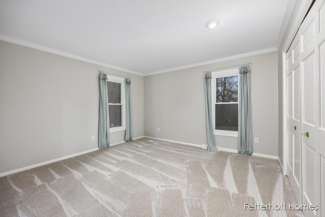 unfurnished bedroom featuring baseboards, ornamental molding, and light colored carpet