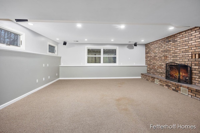 unfurnished living room featuring carpet floors, recessed lighting, a brick fireplace, and baseboards