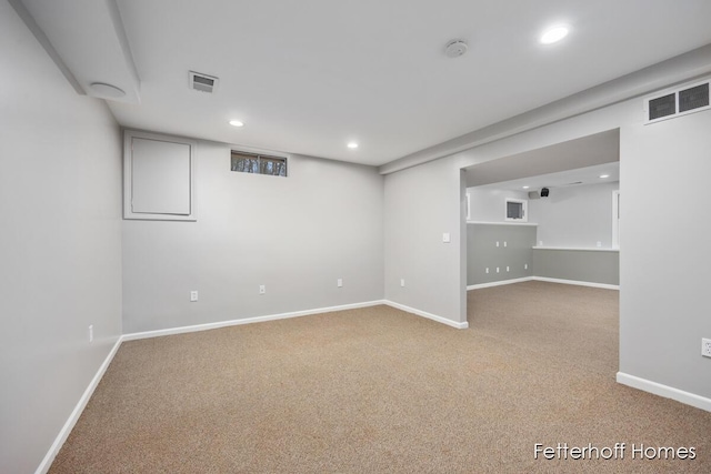 finished basement with carpet, visible vents, baseboards, and recessed lighting