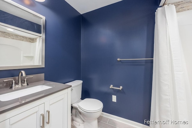 bathroom featuring curtained shower, vanity, toilet, and baseboards